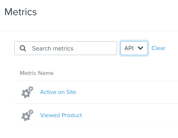 Aba "Métricas" na Klaviyo, filtrada por API, mostrando Ativo no Site e Produto Visualizado na lista, com ícones de engrenagem